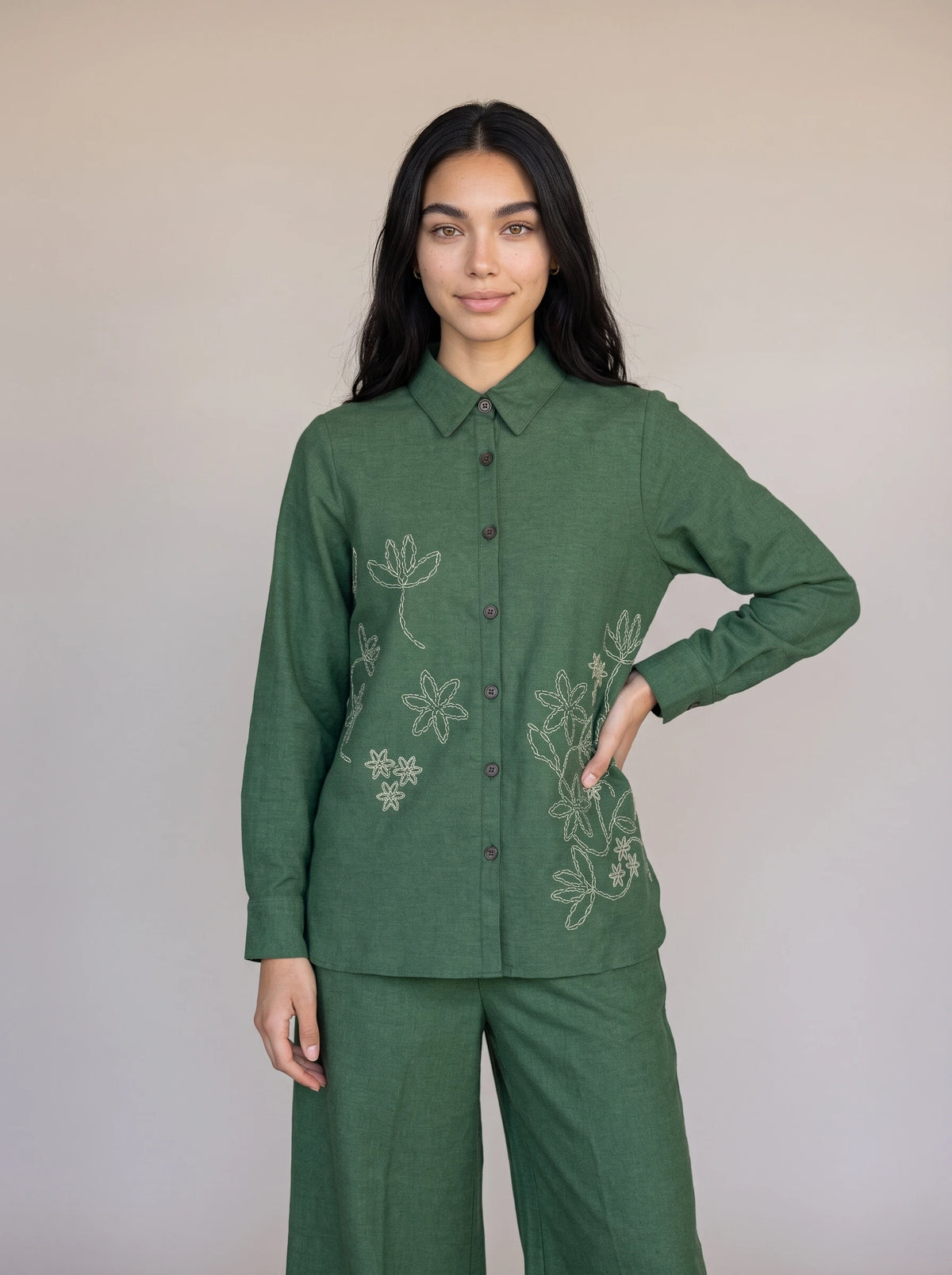 A woman wearing an olive green embroidered co-ord set with a button-front kurta top and matching wide-leg trousers, styled with brown kolhapuri sandals — Beyond East Fall Winter 2026 Pakistani fashion