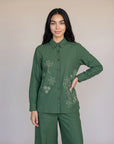 A woman wearing an olive green embroidered co-ord set with a button-front kurta top and matching wide-leg trousers, styled with brown kolhapuri sandals — Beyond East Fall Winter 2026 Pakistani fashion