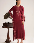A woman wearing a maroon raw silk embroidered kaftan dress with gold threadwork and matching trousers, standing beside a vintage gramophone — Beyond East Fall Winter 2026 Pakistani kaftan collection