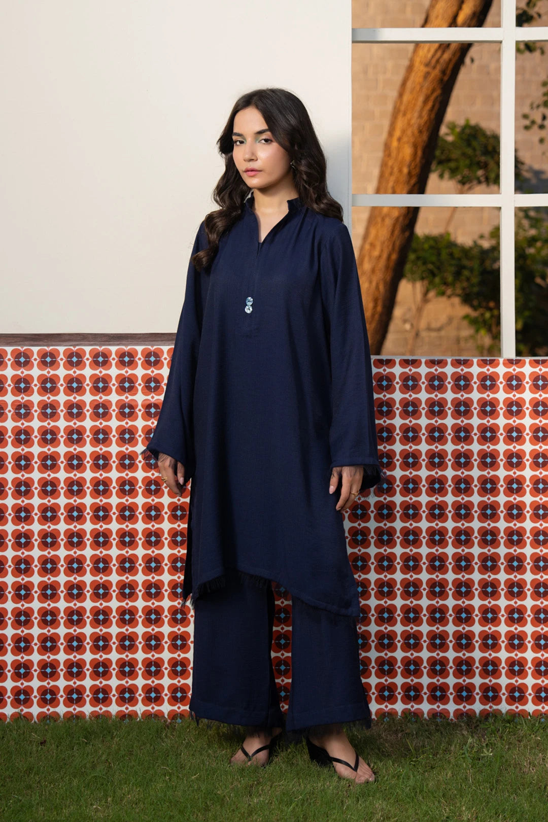A woman wearing a navy blue stitched Pakistani salwar kameez with wide-leg trousers, in a solid minimal design — Beyond East Fall Winter 2026 ready to wear collection