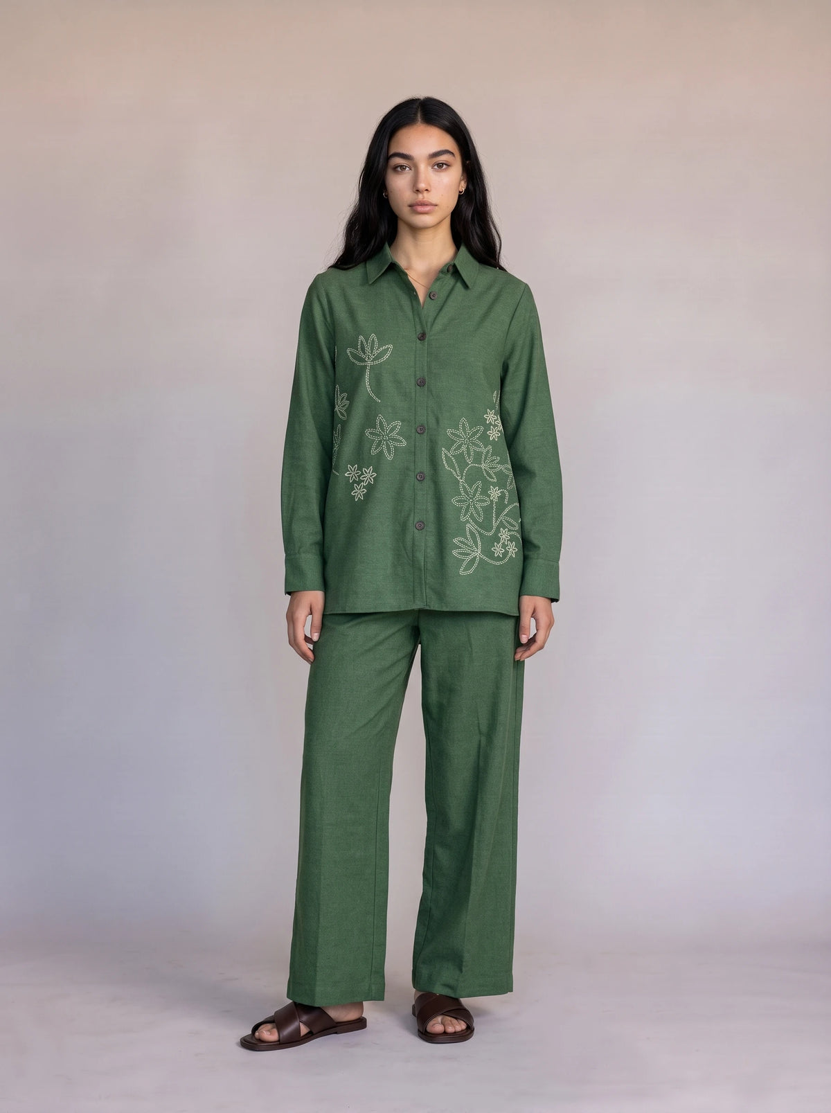 A woman wearing an olive green embroidered co-ord set with a button-front kurta top and matching wide-leg trousers, styled with brown kolhapuri sandals — Beyond East Fall Winter 2026 Pakistani fashion