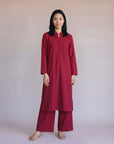 Woman wearing a solid maroon co-ord set with wide leg palazzo trousers and matching kurta top from Beyond East Pakistani fashion collection